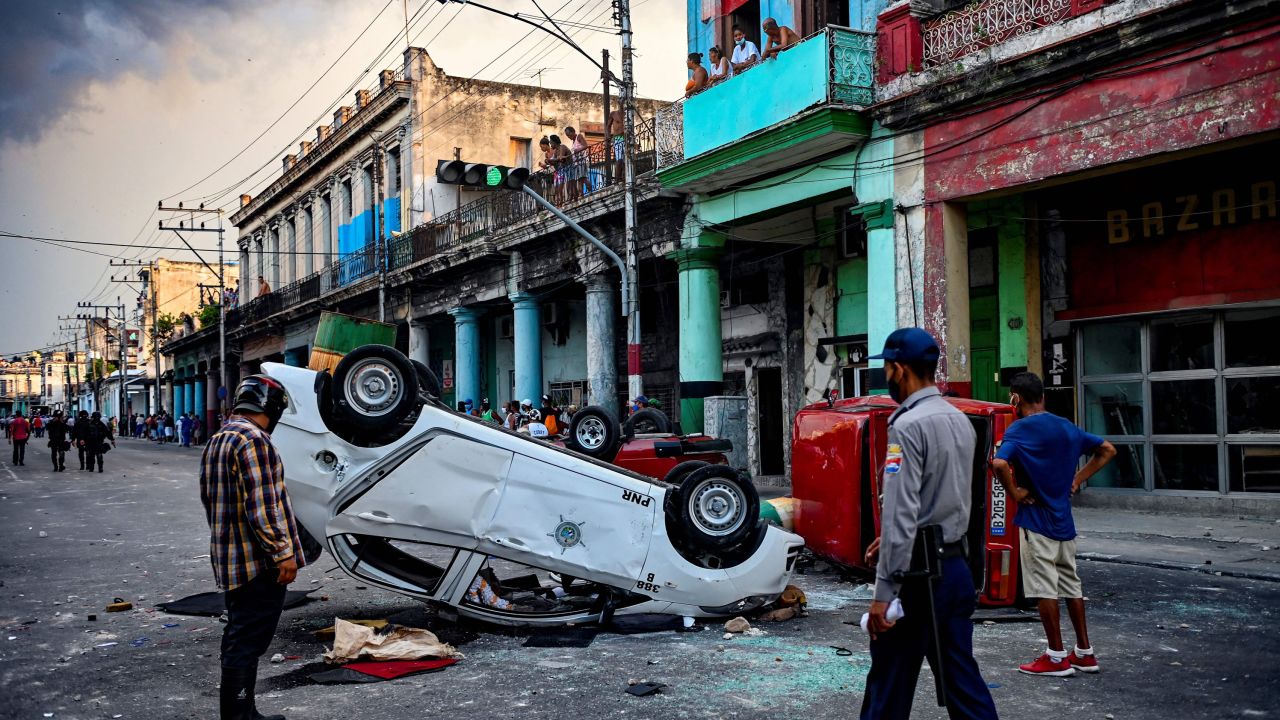 A police car is overturned during a demonstration against Cuban President Miguel Diaz-Canel in Havana on July 11. 