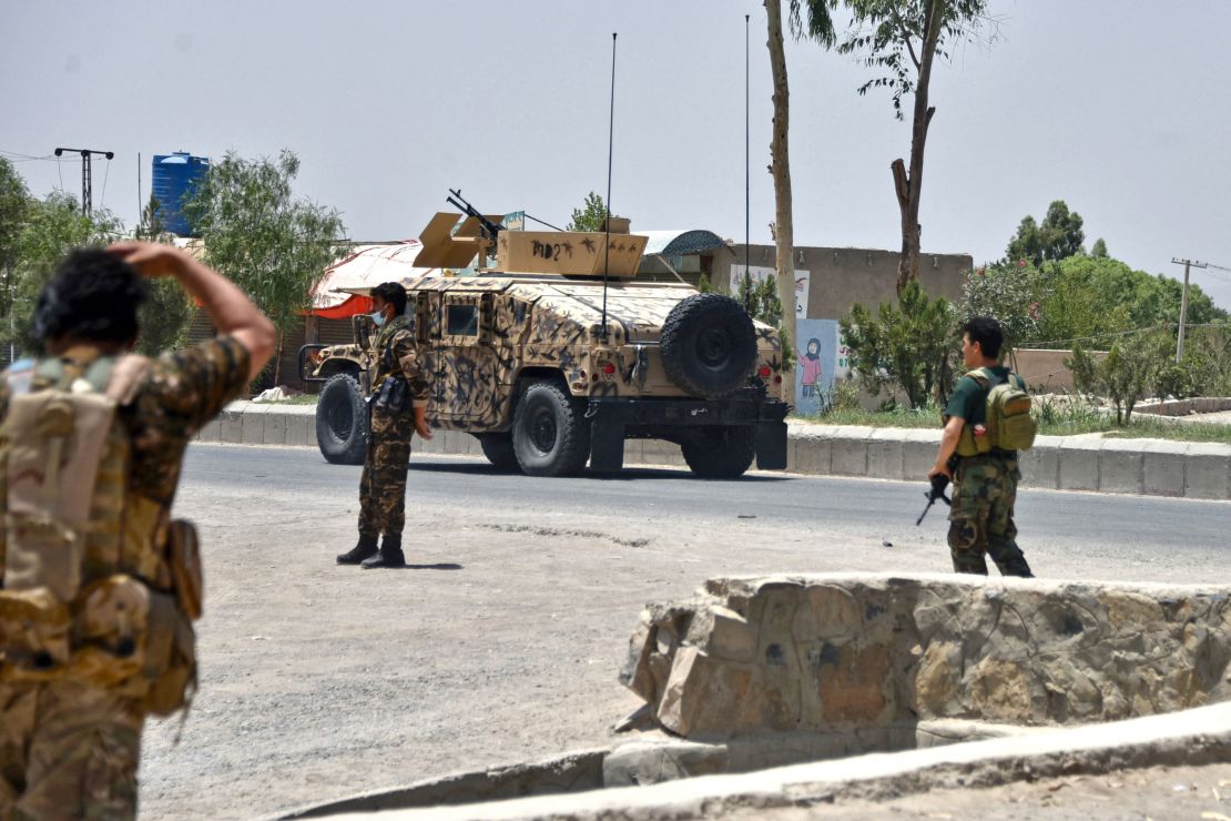 Afghan security personnel stand guard along a road during an ongoing fight between Afghan forces and Taliban fighters in Kandahar on July 9.