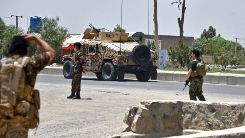 Afghan security personnel stand guard along a road during an ongoing fight between Afghan forces and Taliban fighters in Kandahar on July 9.
