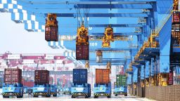 Gantry cranes move containers onto transporters at a port in Qingdao in eastern China's Shandong province Friday, June 4, 2021. 