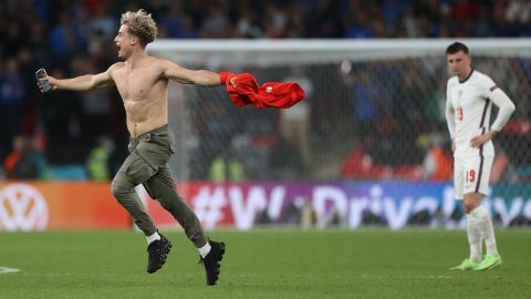 A pitch invader gestures as he runs on the pitch during the Euro 2020 final.