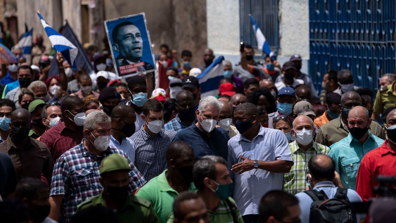 President Miguel Diaz-Canel (in dark blue shirt, wearing a mask) walks with supporters Sunday after an anti-government protest in San Antonio de los Banos, Cuba.