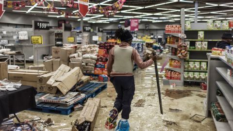 A police officer inspects the damage at a looted mall in Vosloorus, South Africa, on Tuesday.