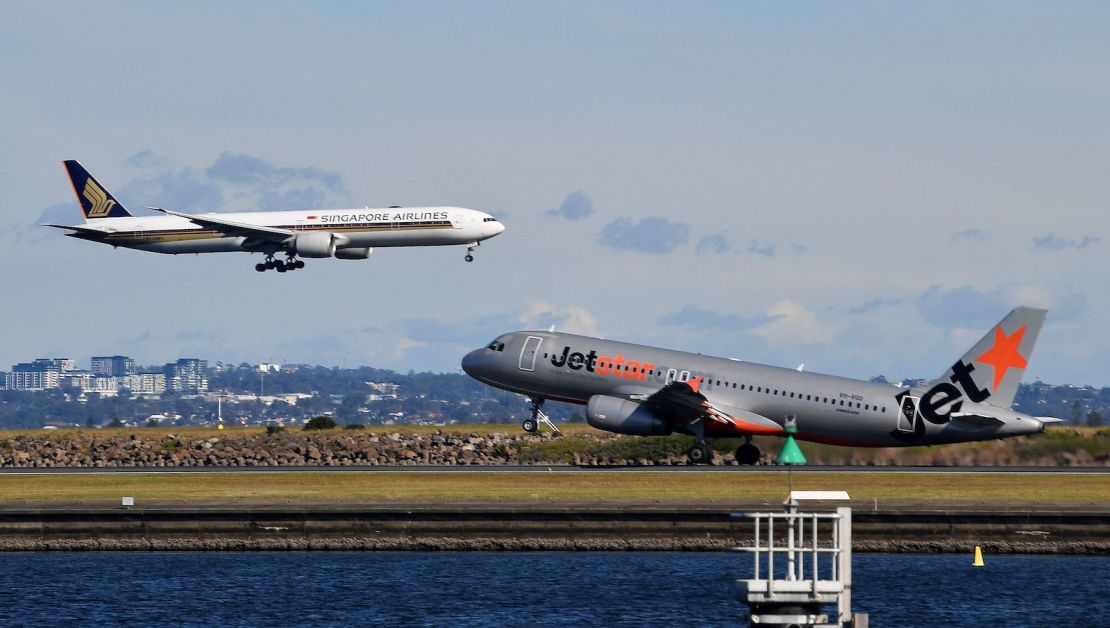A Singapore Airlines flight lands next to a departing Jet Star aircraft at Sydney Airport on June 4, 2021.