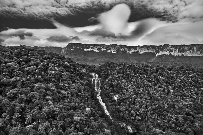 Cotingo River Falls in the foreground and Mount Roraima in the background, Raposa-Serra do Sol Indigenous Territory, Roraima state, 2018. The mountain's name is associated with Makunaima, a mythological hero who inspired the classic novel "Macunaíma" by Brazilian author Mario de Andrade, says Salgado.