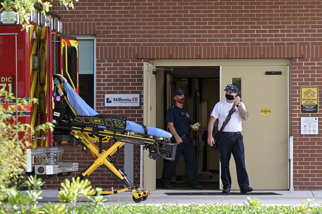 Emergency personnel wear face masks to help prevent the spread of Covid-19 while leaving an hospital clinic emergency room on March 24, 2021, in Orlando, Florida. Parts of the state are now seeing a surge of patients