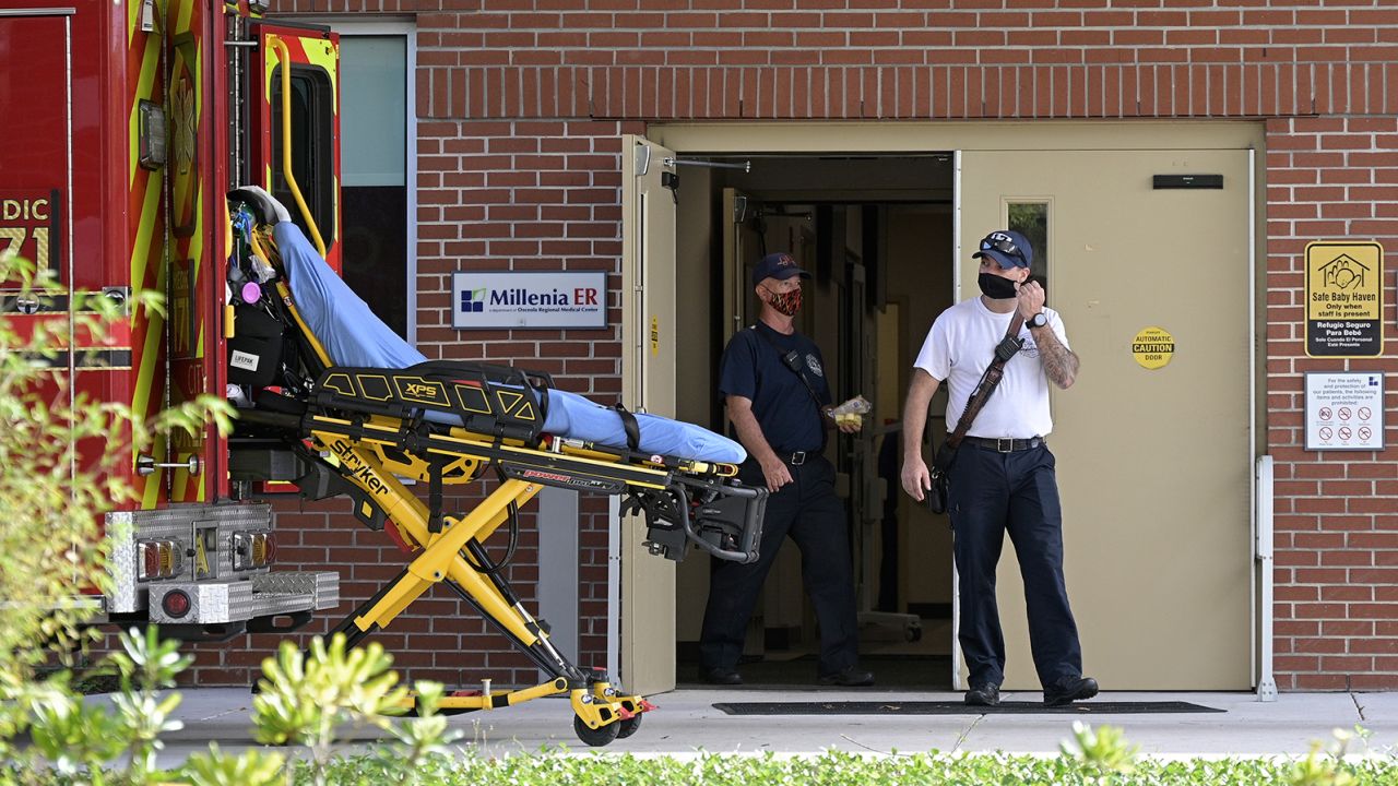 Emergency personnel wear face masks to help prevent the spread of Covid-19 while leaving an hospital clinic emergency room on March 24, 2021, in Orlando, Florida. Parts of the state are now seeing a surge of patients