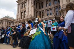 Activists with Jolt Action dressed in quinceañera attire in front of the Capitol. 