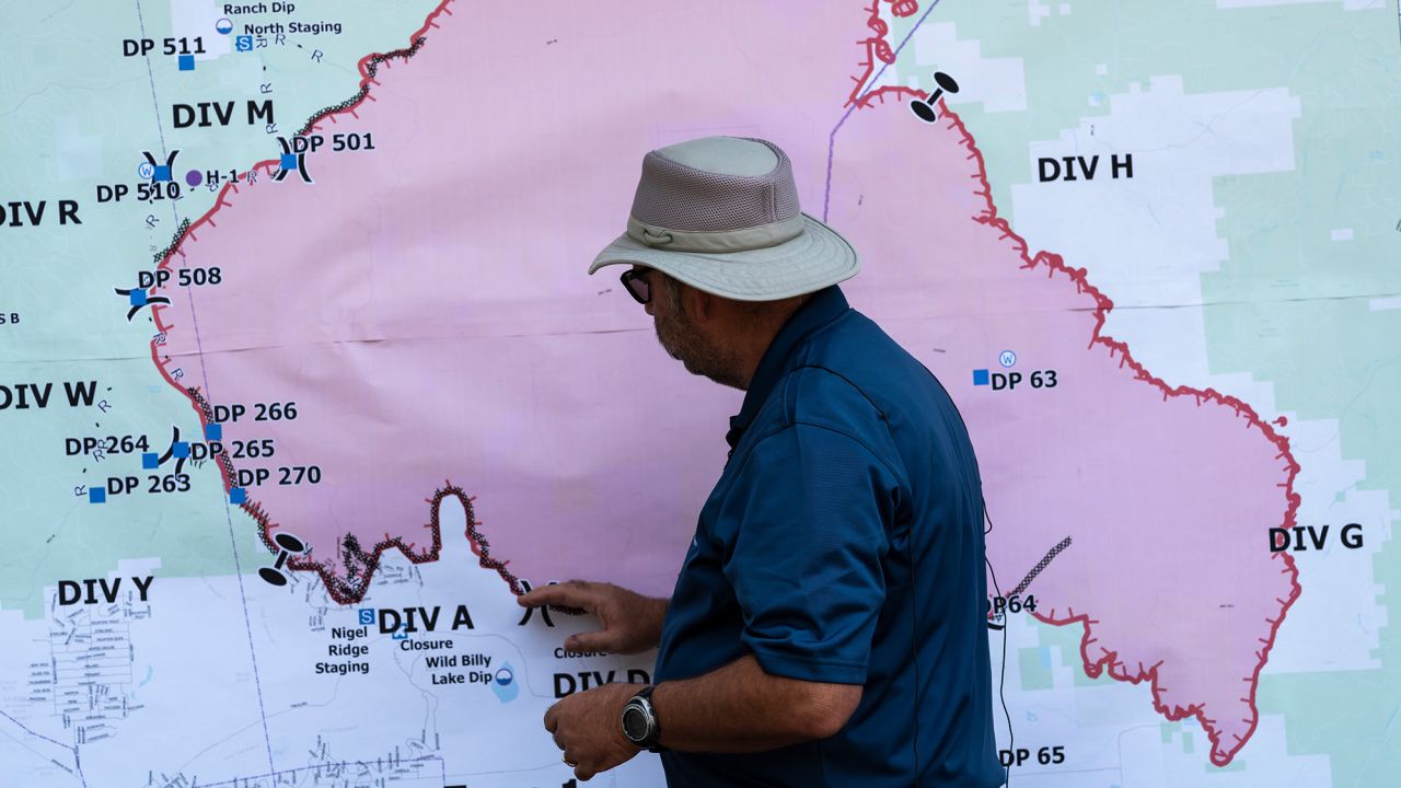 Operations Section Chief Bert Thayer examines a map of the Bootleg Fire on Tuesday in Chiloquin, Oregon. 