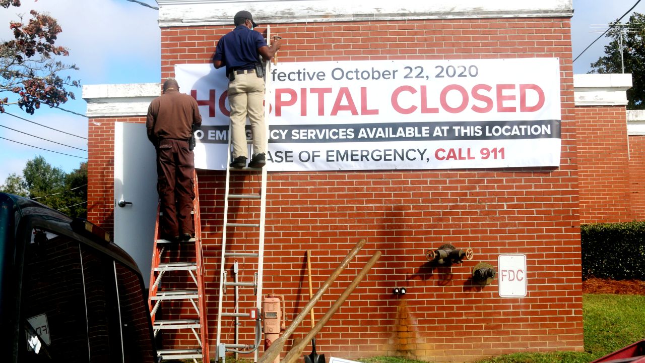 Maintenance staff put up a closed sign for a rural hospital in Cuthbert, GA. A record number of rural hospitals shut down in the pandemic.