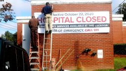 Maintenance staff put up a closed sign for a rural hospital in Cuthbert, GA. A record number of rural hospitals shut down in the pandemic. 