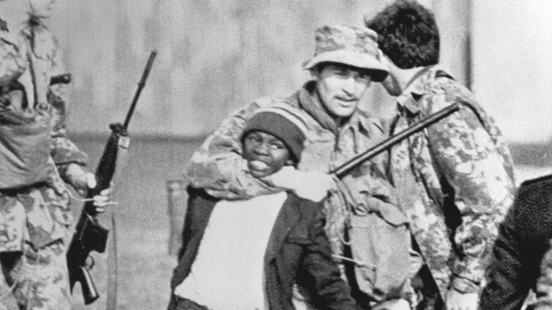 Police drag a young black student to a police van after rioting broke out on Wednesday, August 12, 1976 in a African township  near Cape Town, South Africa. Images of White police brutalizing Blacks were common during the apartheid era.