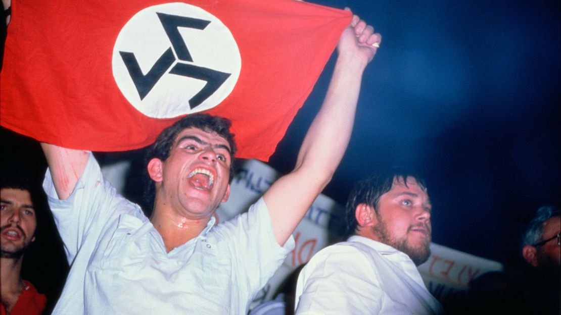 White South African man holds up a flag for the Afrikaner Resistance Movement (AWB), one of many groups that once threatened to push the nation into a civil war.