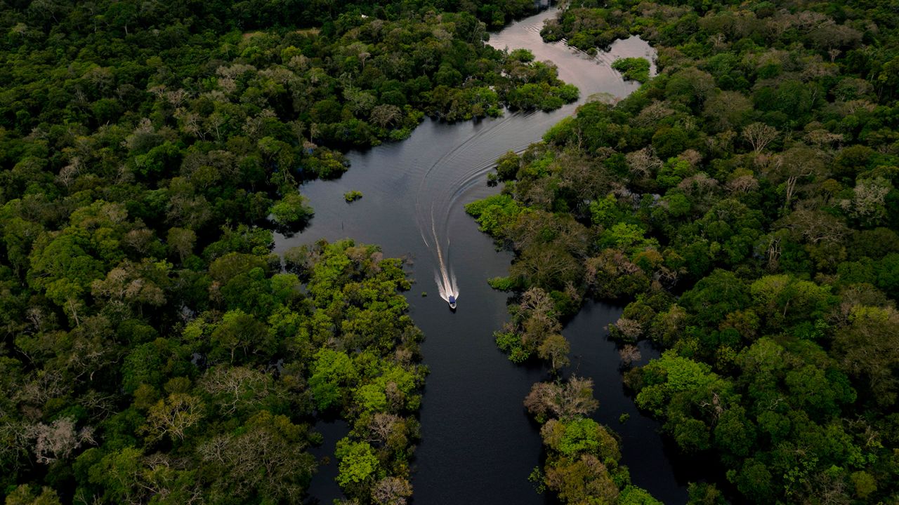 Aerial view showing a boat speeding on the Jurura river in the municipality of Carauari, in the heart of the Brazilian Amazon Forest, on March 15, 2020.