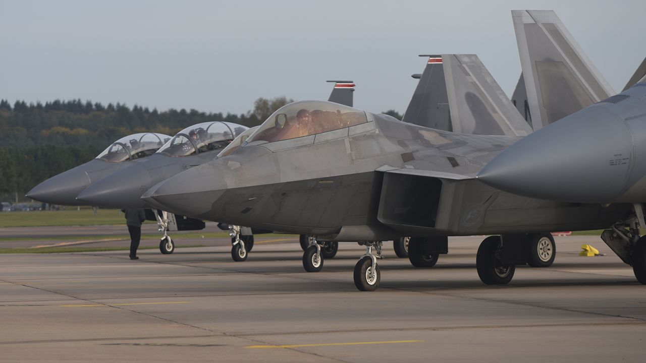 A US Air Force F-22 Raptor lines up next to three F-15E Strike Eagles at Royal Air Force Lakenheath, England, in 2017.