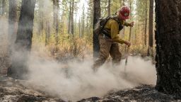 Firefighter Garrett Suza, with the Chiloquin Forest Service, mops up a hot spot on the North East side of the Bootleg Fire, Wednesday, July 14, 2021, near Sprague River, Ore. (AP Photo/Nathan Howard)