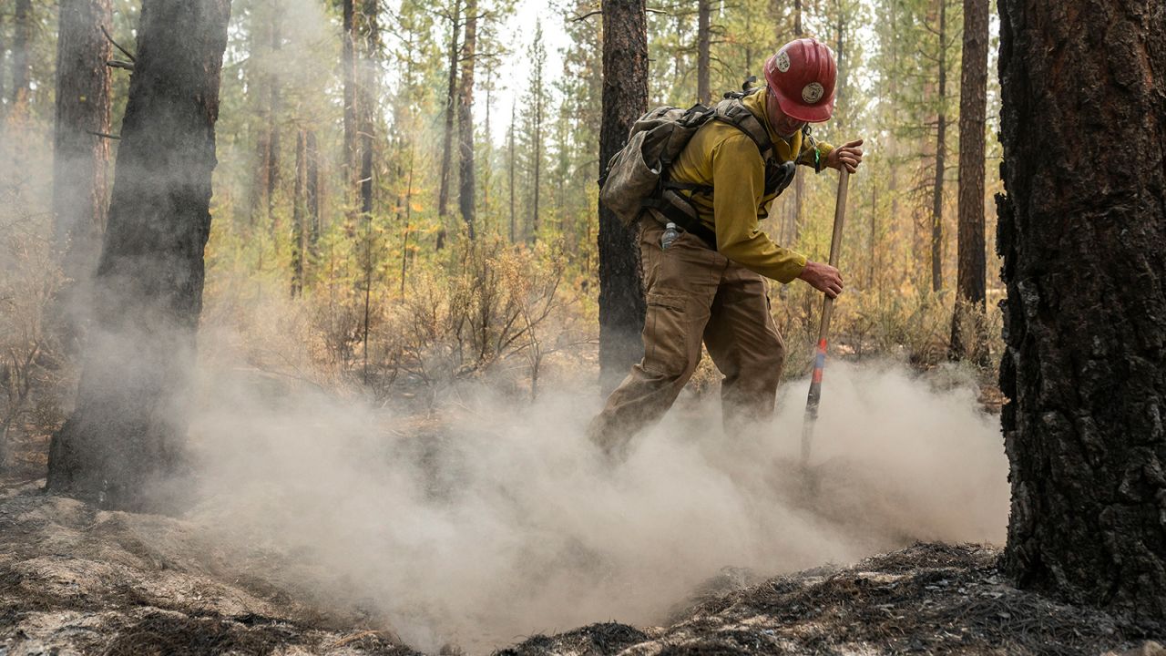 Firefighter Garrett Suza, with the Chiloquin Forest Service, mops up a hot spot on the North East side of the Bootleg Fire on Wednesday.