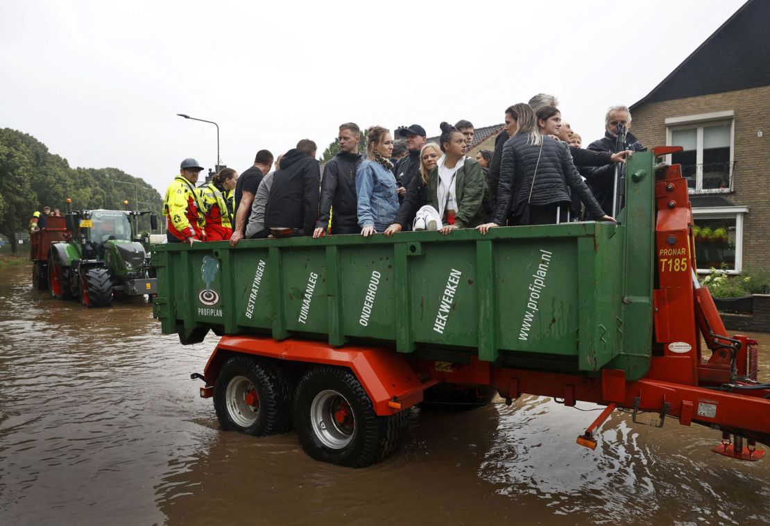 People ride on a trailer as the Dutch fire brigade evacuate people from their homes in South Limburg.