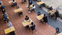 Customers sit at socially distanced tables outside a restaurant in Singapore, on Monday, June 21, 2021. Singapore has decided to scale down its reopening plans amid dozens of new cases over the last week, even as some countries with similarly high rates of vaccination allow a resumption of social activities and freer travel. Photographer: Wei Leng Tay/Bloomberg via Getty Images
