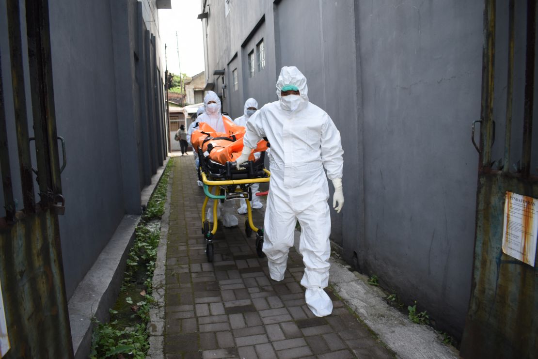 Health workers remove the body of a Covid-19 victim who died while isolating at home in Indonesia on Wednesday. 