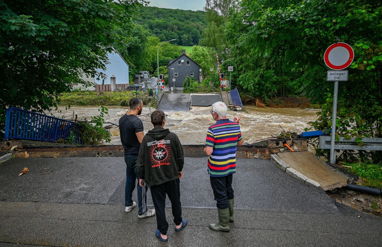 People look at a railway crossing that was destroyed by the flooding in Priorei, Germany.