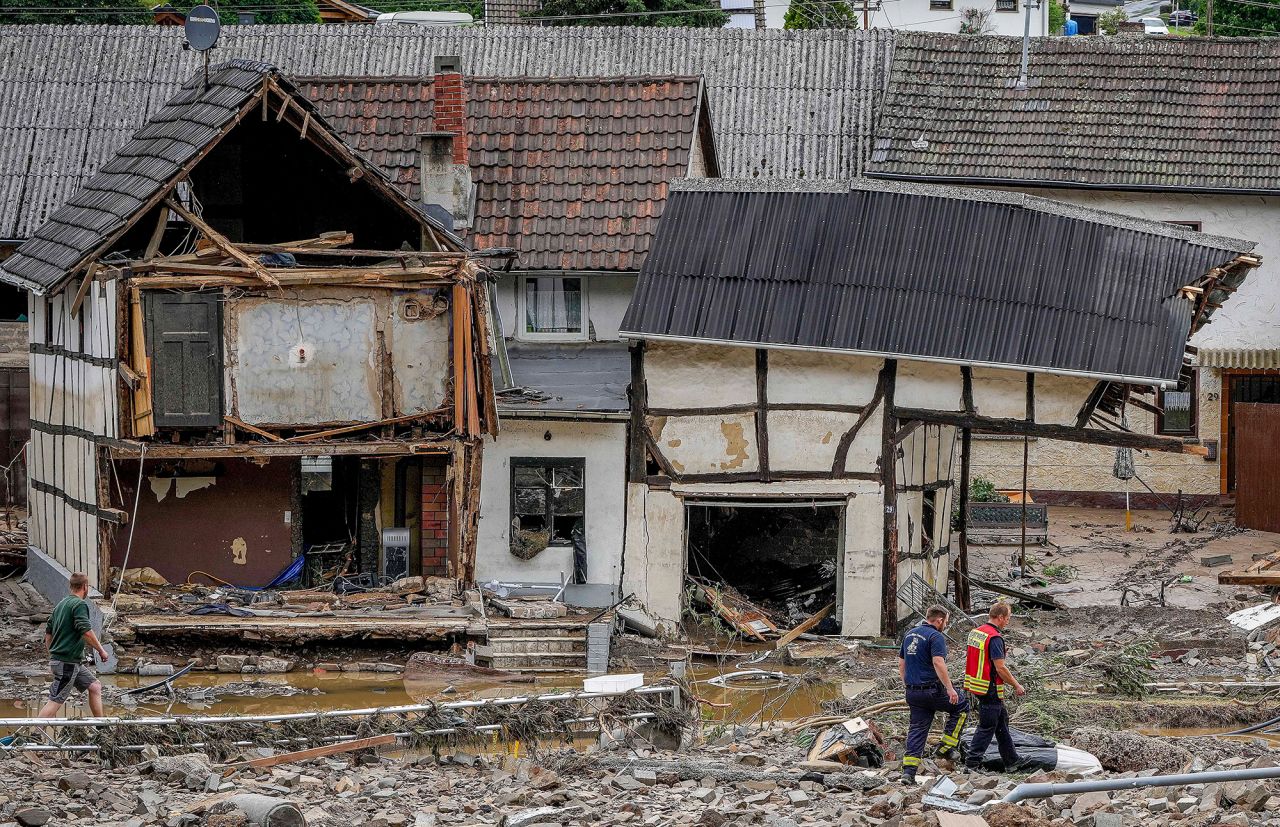 Men walk by damaged homes in Schuld, Germany.