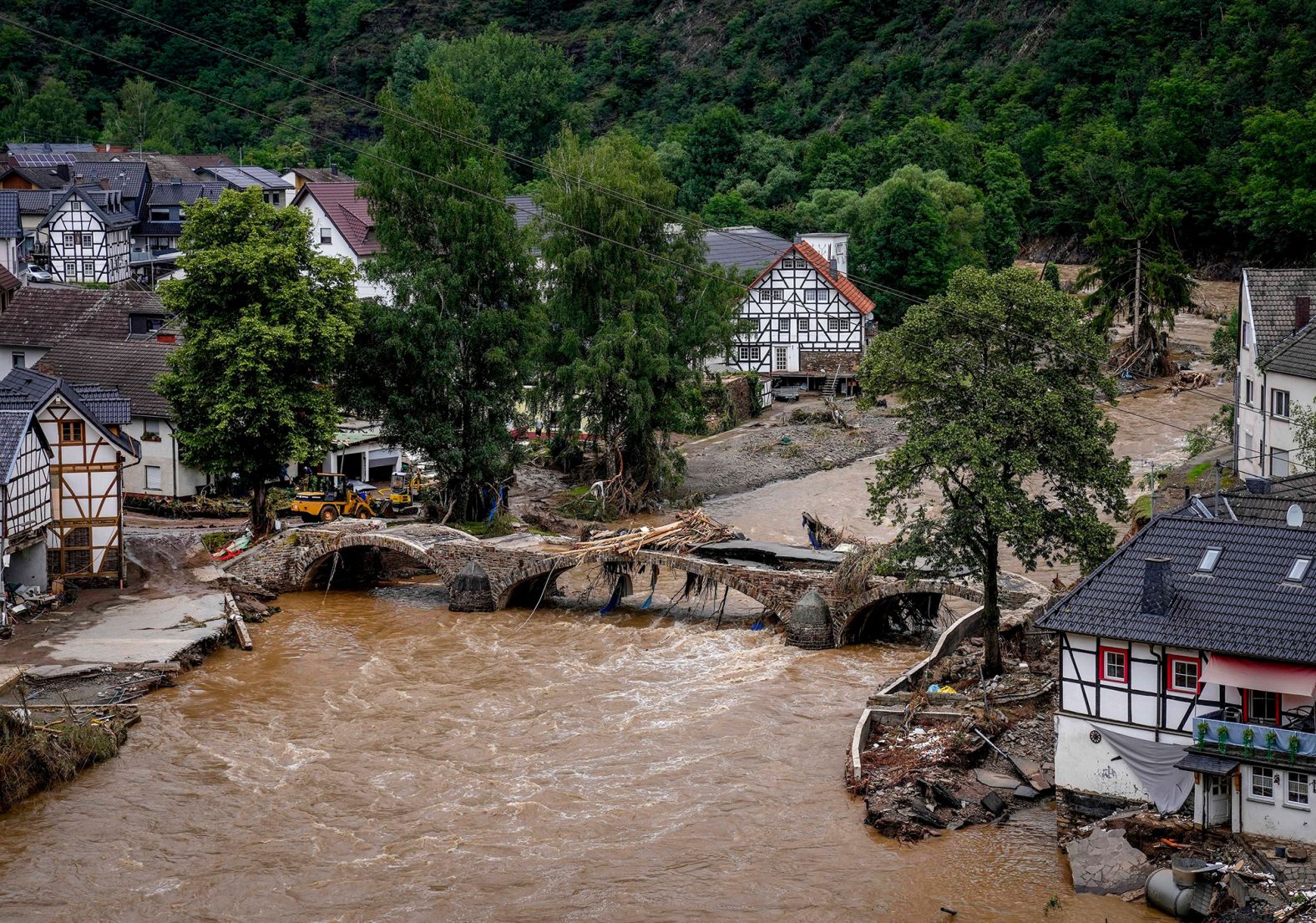 Water from the Ahr River flows past a damaged bridge in Schuld.