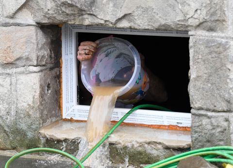 A resident uses a bucket to remove water from a house cellar in Hagen, Germany.
