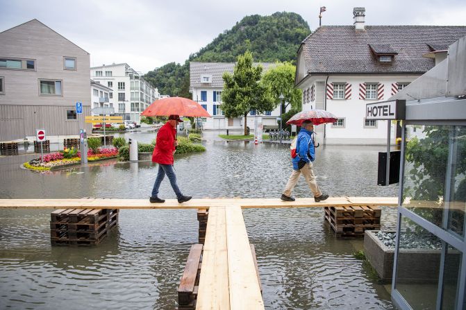 People walk over floodwaters in Stansstad, Switzerland.