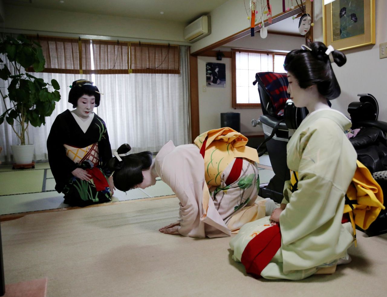 Geishas Mayu and Maki bow to Ikuko before making their way to work at a party being hosted by customers during the coronavirus pandemic in June 2020.
