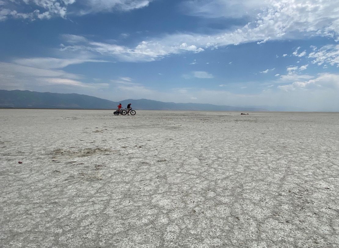 Lucy Kafanov of CNN and Kevin Perry ride bikes Tuesday on the dry lake bed playa of the Great Salt Lake.