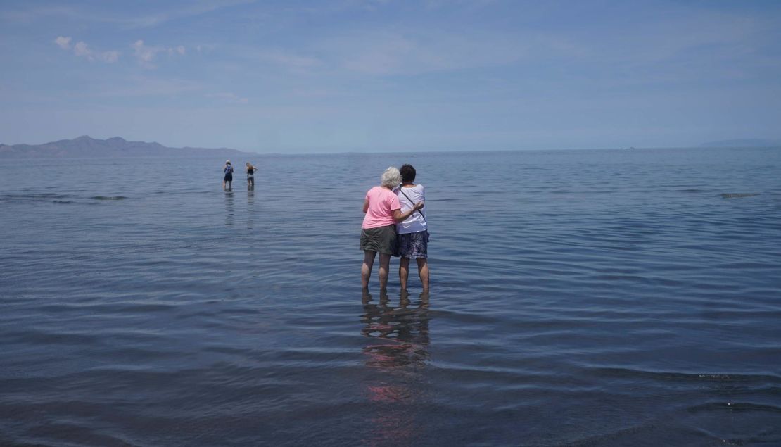 Visitors stand in June in the shallow waters of the Great Salt Lake.