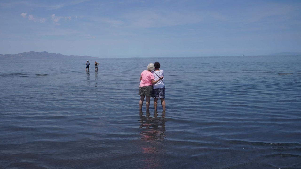 Visitors stand in June in the shallow waters of the Great Salt Lake.
