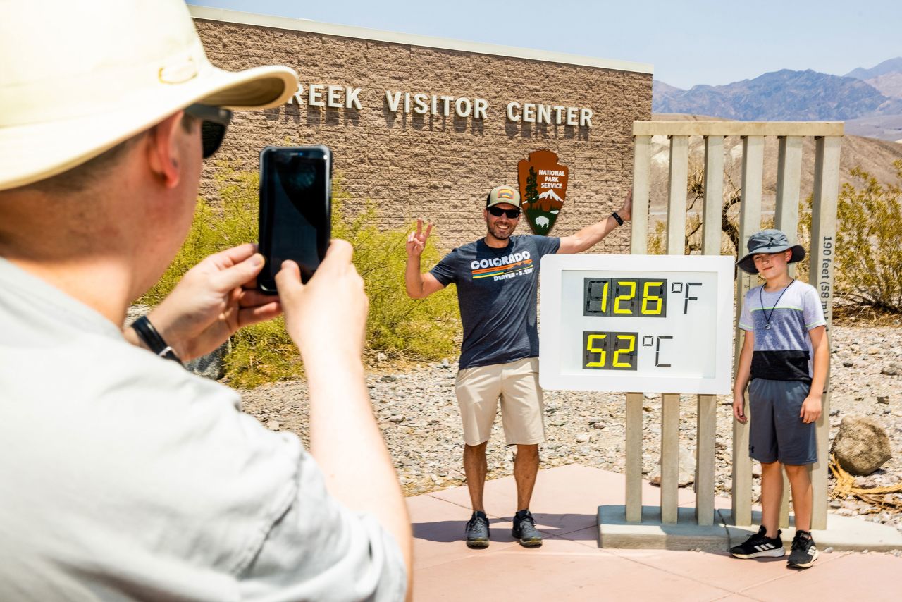Visitors take photos in front of a thermometer at Death Valley National Park in Death Valley, California, on Saturday, July 10. A day earlier, <a href="https://www.cnn.com/2021/07/11/weather/weather-death-valley-heat-record-california-weekend/index.html" target="_blank">the park hit 130 degrees Fahrenheit</a> for only the fifth time in recorded history.