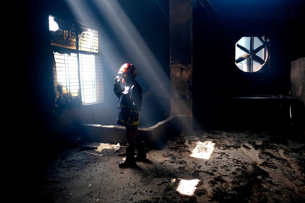 A firefighter uses a walkie-talkie to communicate with his colleagues inside a juice factory in Rupganj, Bangladesh, on Friday, July 9. <a href="https://www.cnn.com/2021/07/10/asia/bangladesh-factory-fire-intl/index.html" target="_blank">A massive fire had ripped through the factory,</a> killing at least 52 people and injuring at least 50.