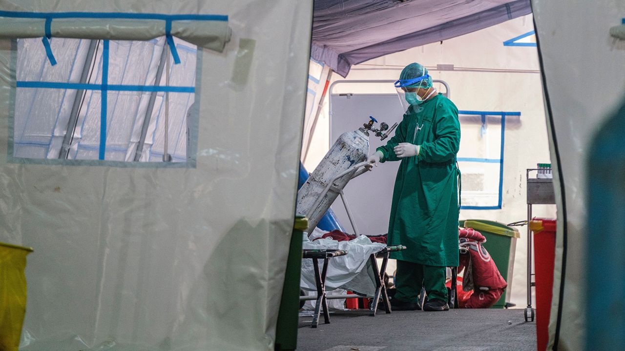 A medical personnel changes out an oxygen tank in a tent set up at a public hospital to handle the overflow of Covid-19 patients on June 24, 2021 in Jakarta, Indonesia.