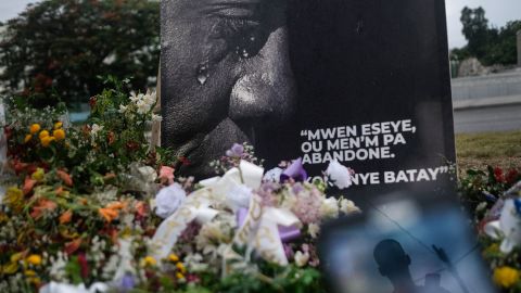 A man is reflected on a cellphone at a memorial outside the Presidential Palace in memory of slain President Jovenel Moise, in Port-au-Prince, Haiti, Wednesday, July 14, 2021.