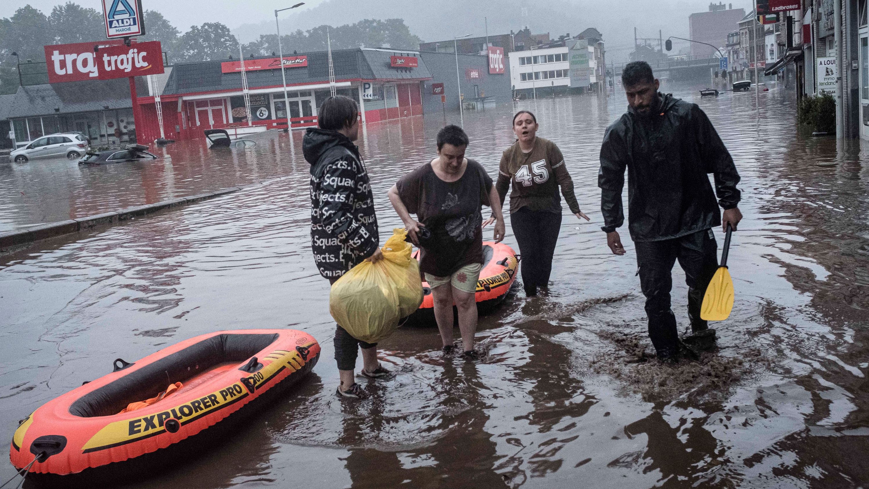 People use rafts to evacuate after the Meuse River broke its banks during heavy flooding in Liege, Belgium.
