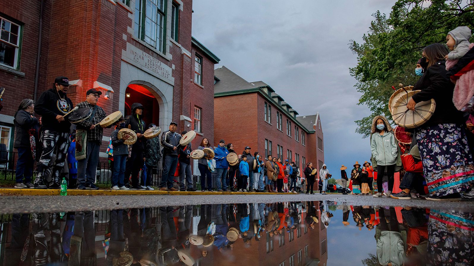 Drummers line the front of the former Kamloops Indian Residential School to welcome a group of runners from the Syilx Okanagan Nation on June 5, 2021.