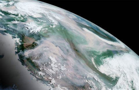 In this GeoColor image from July 12, smoke from numerous wildfires could be seen as gray-brown, in stark contrast to the white cloud cover over other parts of the continent.