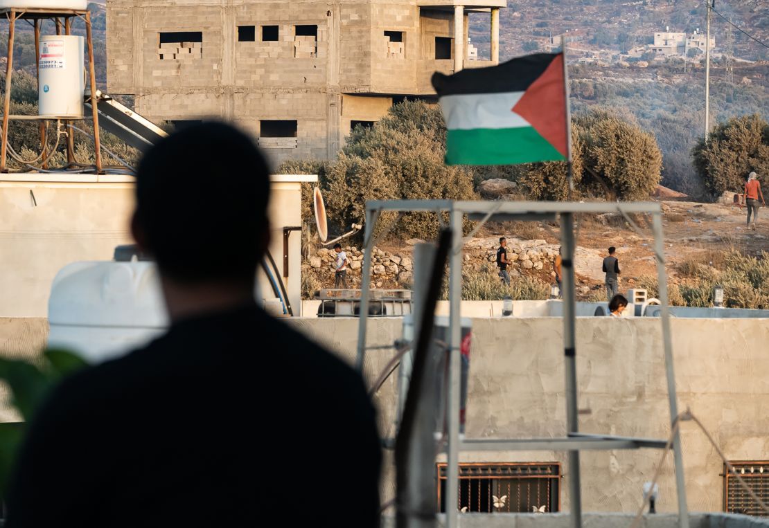 The Palestinian flag flies above the scene of clashes between Palestinians and Israeli soldiers in Beita.