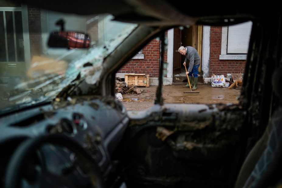 A man brushes water and mud out of his flooded house in Ensival, Belgium, on Friday.