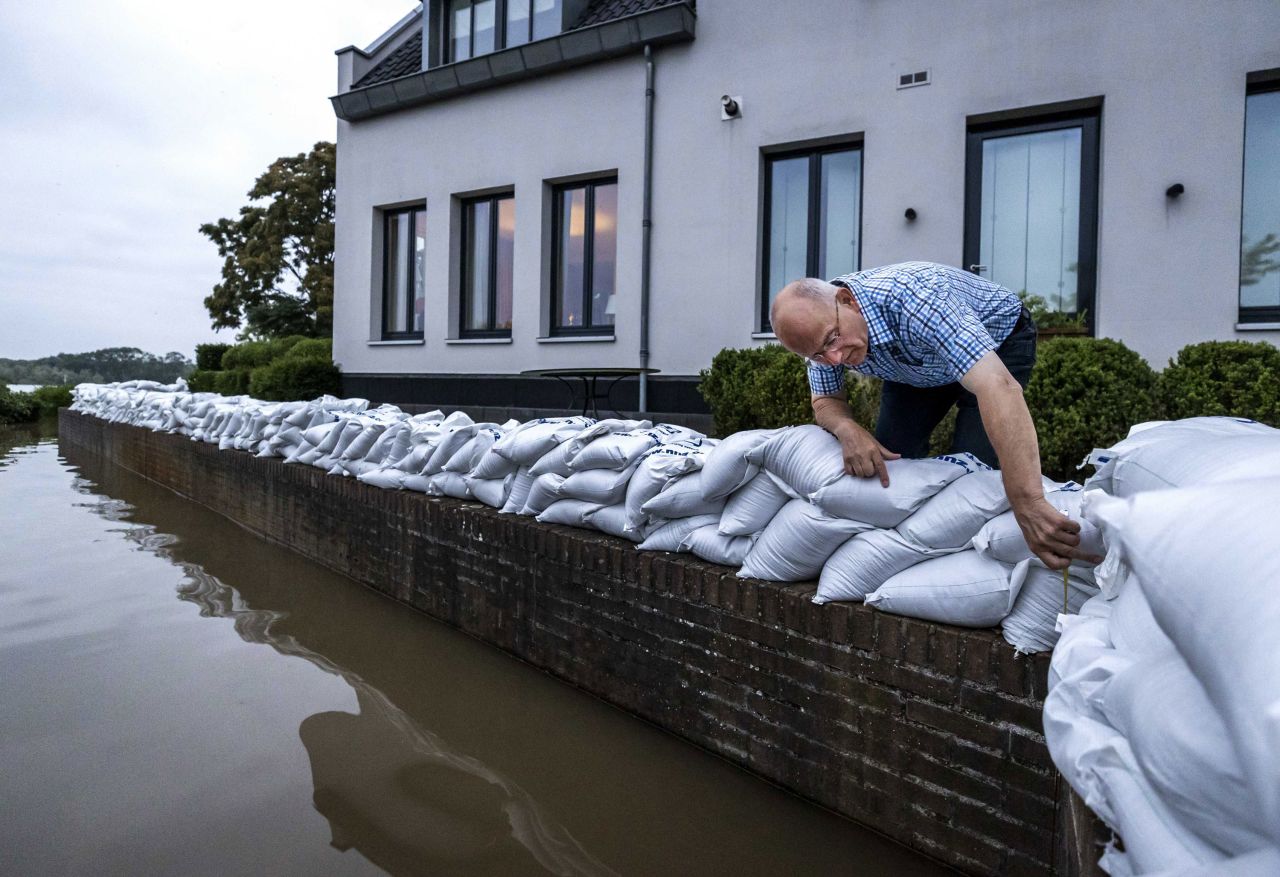 A resident of Arcen, Netherlands, looks at the rising water of the Meuse River on Saturday.