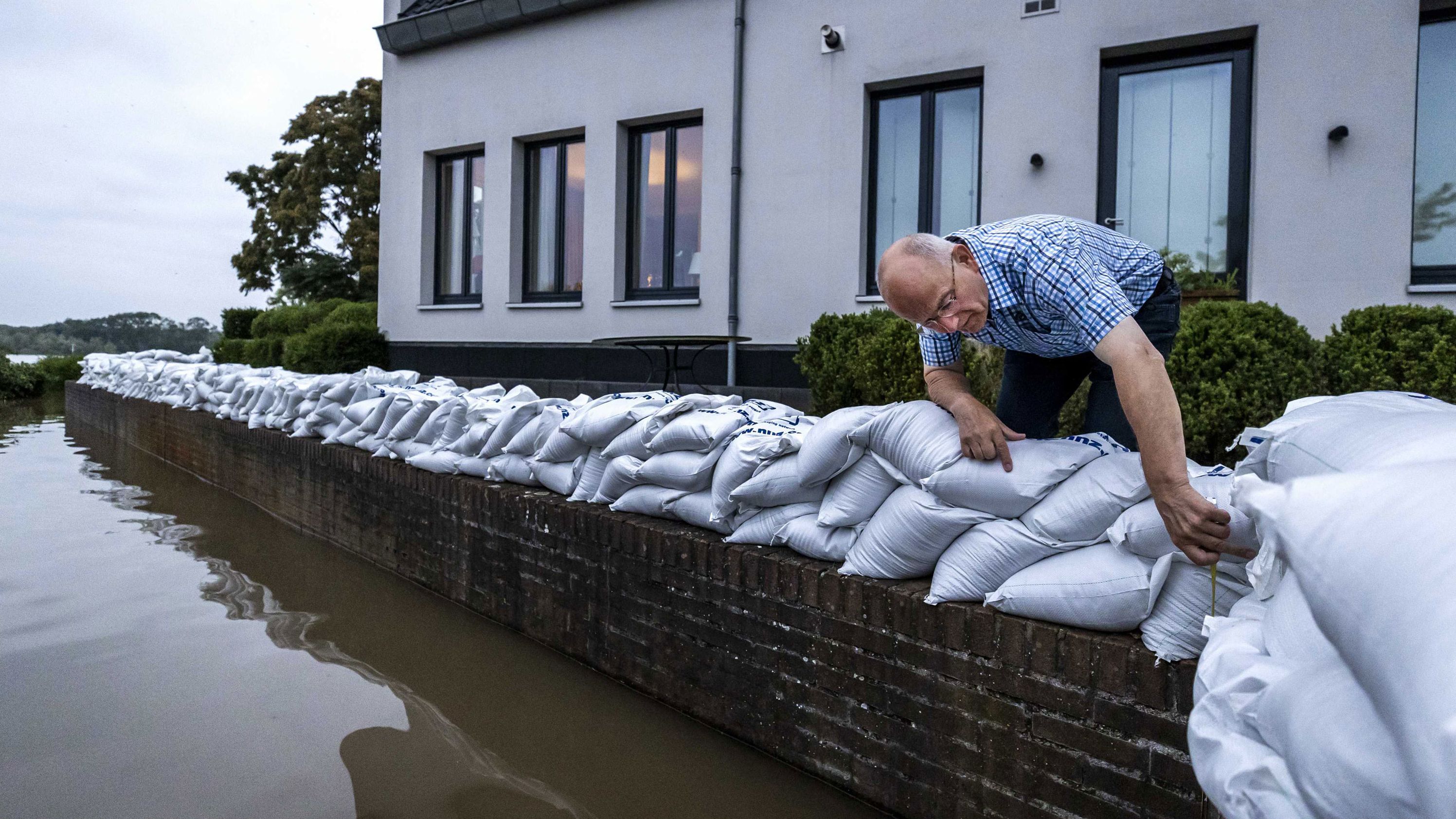 A resident of Arcen, Netherlands, looks at the rising water of the Meuse River on Saturday.