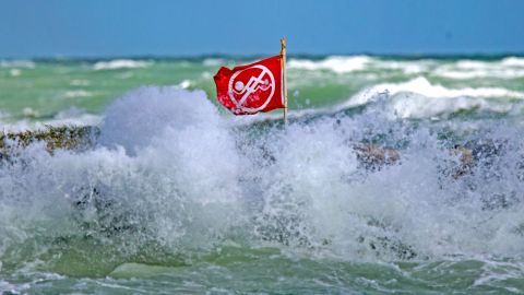 Waves crash around a no-swimming flag at Haulover Park beach in Miami Beach, Florida, in 2020.