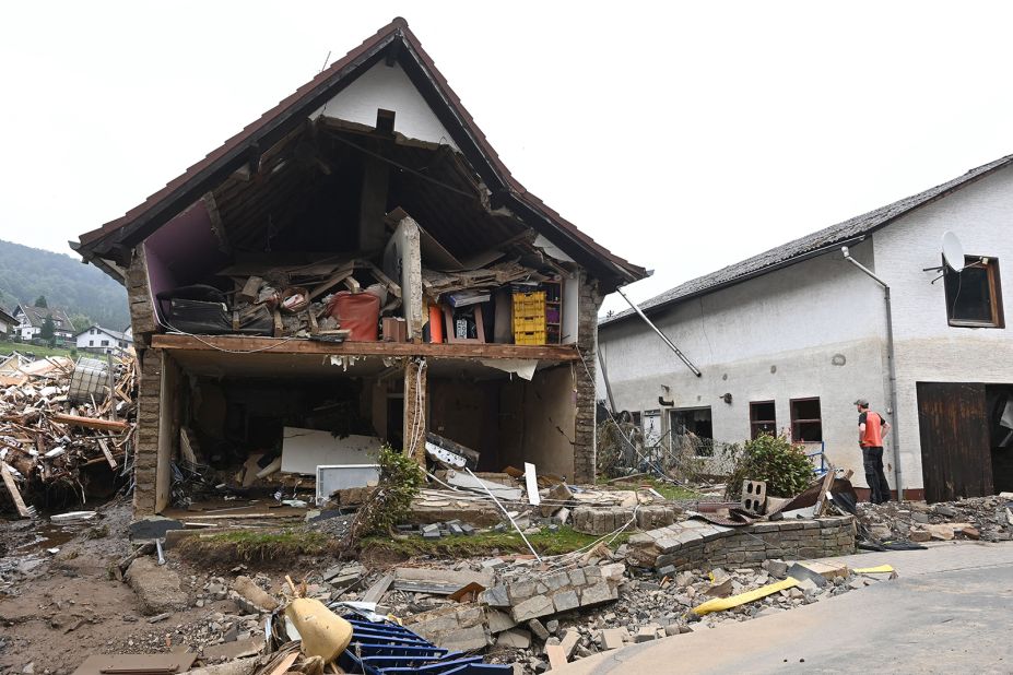 A man stands in front of a destroyed house in Schuld, Germany.