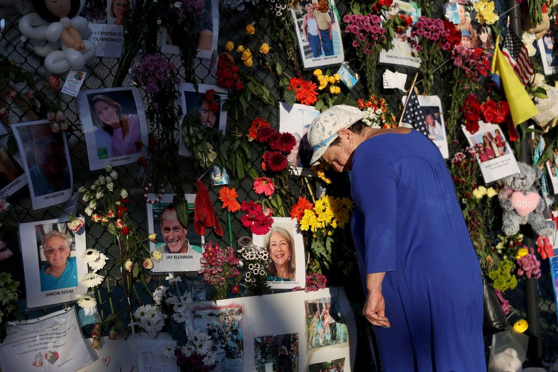 Valerie Flatto visits the memorial bearing photos of some of the victims of the partially collapsed 12-story Champlain Towers South condo building on July 15, 2021 in Surfside, Florida.