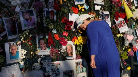 Valerie Flatto visits the memorial bearing photos of some of the victims of the partially collapsed 12-story Champlain Towers South condo building on July 15, 2021 in Surfside, Florida.