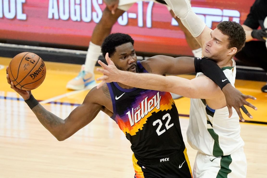 Phoenix Suns center Deandre Ayton (22) is defended by Milwaukee Bucks center Brook Lopez during the first half of Game 5 of basketball's NBA Finals, Saturday, July 17, 2021, in Phoenix.