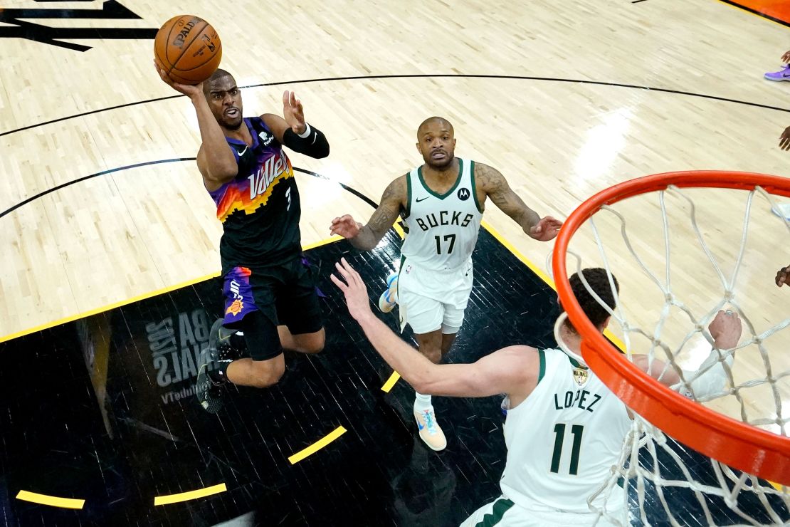 Phoenix Suns guard Chris Paul (3) shoots as Milwaukee Bucks forward P.J. Tucker (17) and center Brook Lopez (11) defend during the first half of Game 5 of basketball's NBA Finals, Saturday, July 17, 2021, in Phoenix.